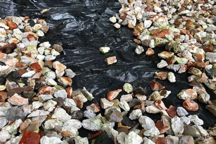 Should you put plastic under pebbles?